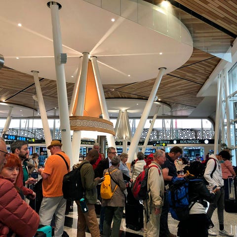 Passengers line up to board one of the few flights