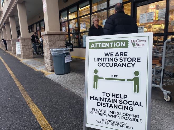 Shoppers line up at a grocery store in Ardsley, NY early Friday morning, March 20, 2020. The store is limiting shoppers and attempting to enforce social distancing.