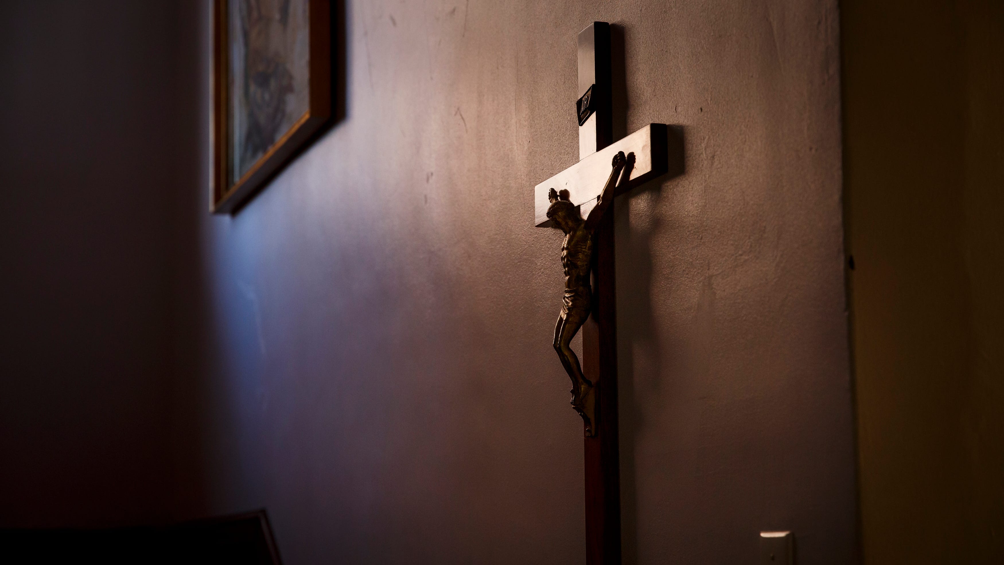 A cross hangs in the hallway as the Rev. Fabian Moncada celebrates Mass in a makeshift chapel as it's streamed live to followers of Our Lady of the Americas Church on Saturday, March 21, 2020, in Des Moines.