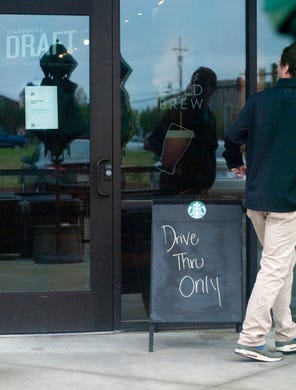 A Starbucks patron at the Baptist Drive location, in Madison, quickly realizes the cafe is closed Saturday, March 21, 2020. On Friday, the Starbucks corporation announced the company will go to drive-through and delivery only for the next two weeks. The company confirmed it will pay U.S. partners for the next 30 days, even if they choose to stay home.