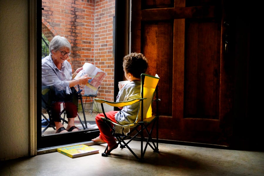 Marilyn Maitland, 72, reads to her 4-year-old grandson, Theo. When coronavirus infiltrated Austin, Texas, they had to read to each other from opposite sides of the door.