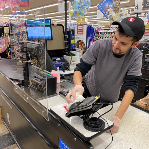 Safeway employee cleans the checkout station in be