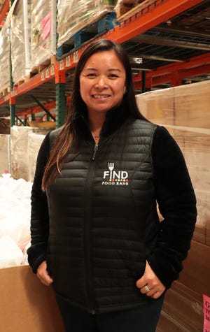 FIND Food Bank CEO Debbie Espinosa poses in front of bags of food in Indio, Calif., that will be distributed to help those affected by the coronavirus outbreak on Monday, March 23, 2020.