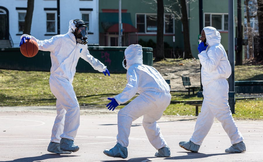 Poughkeepsie, New York, native Tre Mayo sets up to crossover dribble during a pickup basketball game on Saturday, March 21, 2020. He and a group of friends played in hazmat suits amid the coronavirus scare.