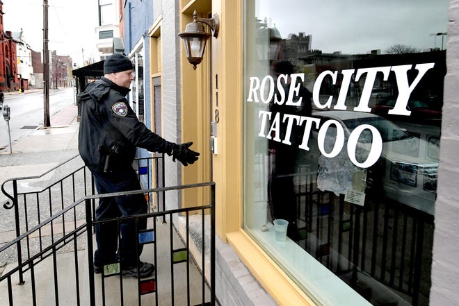 York City Police officer Michael Rykowski checks a locked door at a business on West Philadelphia Street while on patrol Monday, March 23, 2020. He and other police, fire and property management representatives were checking that businesses, schools and organizations were complying with state and city COVID-19 closure orders. Bill Kalina photo