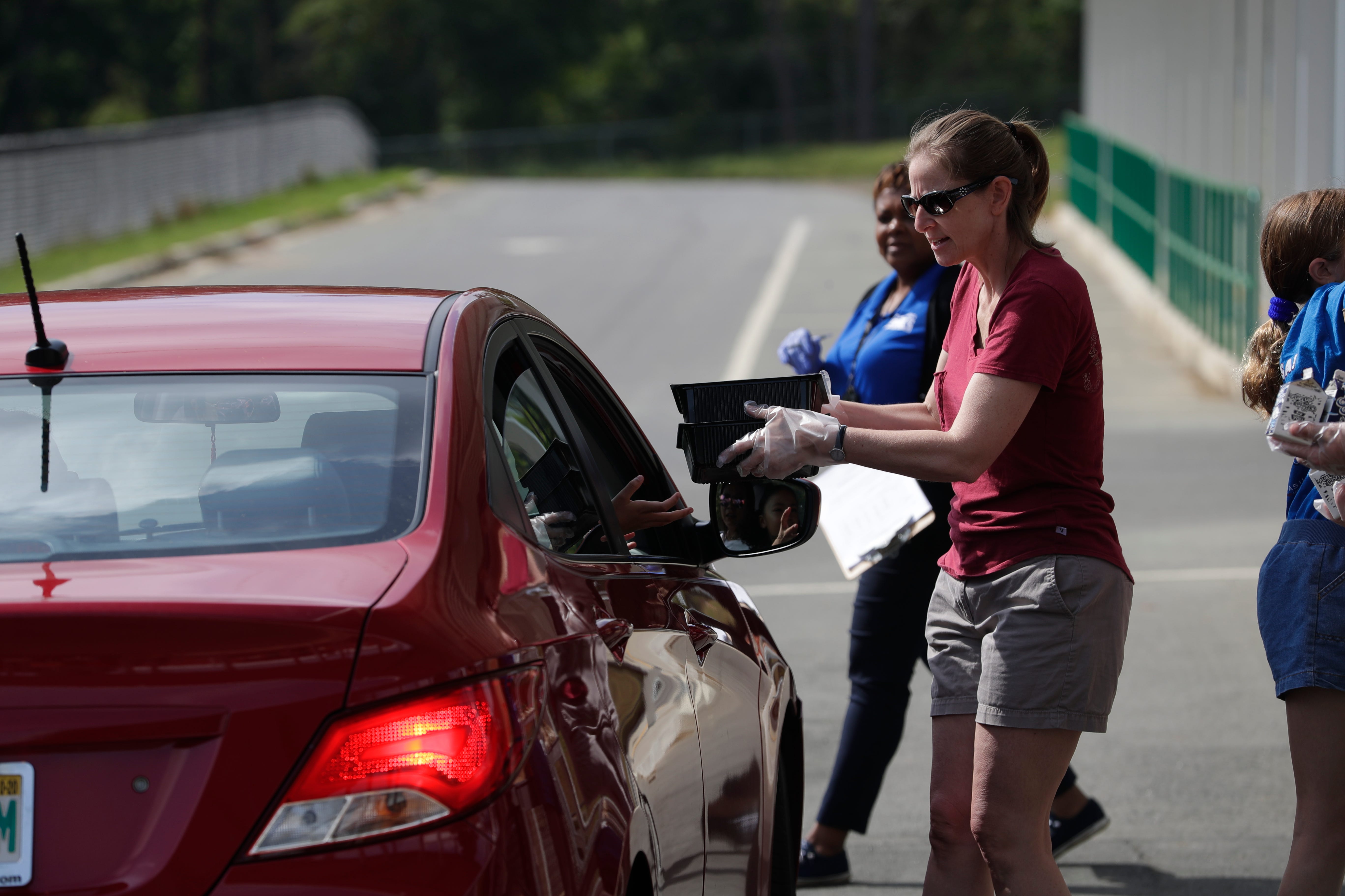 Jennifer Crews, a teacher at Sealey Elementary School, hands out meals to families at W.T. Moore Elementary as Leon County Schools provides foods for students' families Monday, March 23, 2020. 