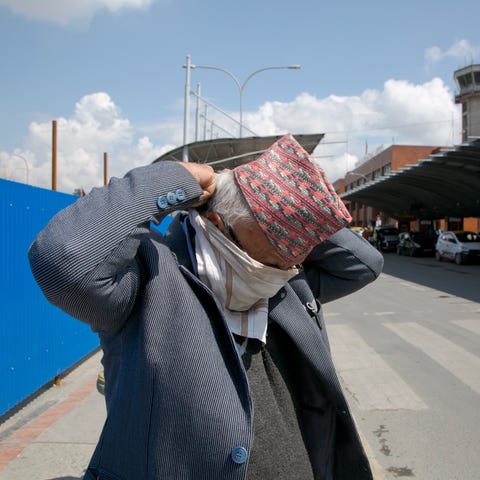 A Nepalese man covers his face with a handkerchief