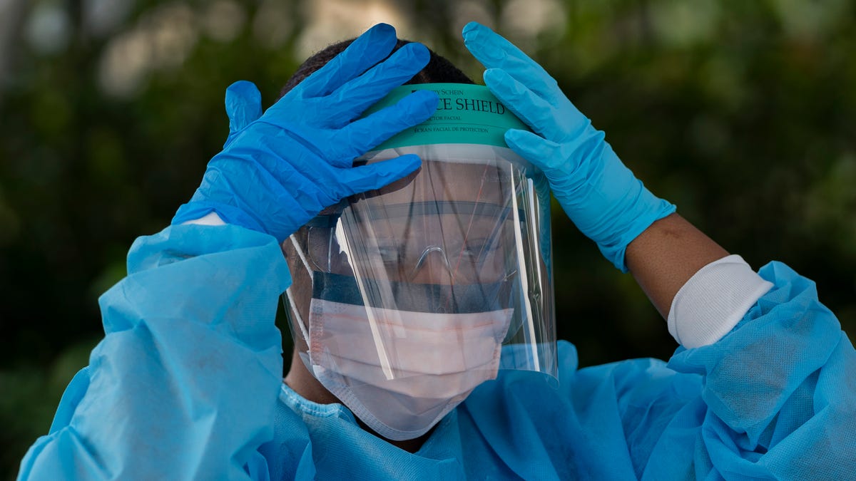 Healthcare worker Ludnie Emile prepares to test people for COVID-19 at their drive-thru coronavirus testing station in Palm Springs, Fla. on March 19, 2020.