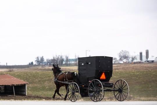An Amish horse-drawn carriage rides along Highway 1 outside of Kalona, Tuesday, March 24, 2020, in Johnson County, Iowa.