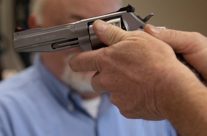 Smyrna Guns customer Doug Timmons handles a revolver as he shops for a handgun March 24, 2020, in Smyrna, Tenn.