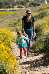 Lisa Nelson of Glendale, hikes with her daughter, Ava Nelson, 2, on a trail at Thunderbird Park in Glendale on March 24, 2020. Hiking trails have been busy as people look to get outside during all the closures because of the coronavirus. 