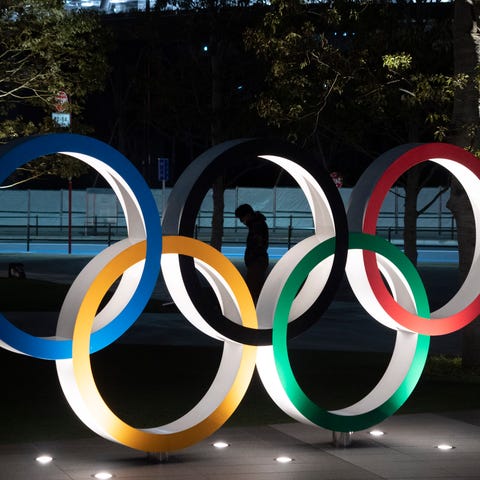 A man is seen through the Olympic rings in front o
