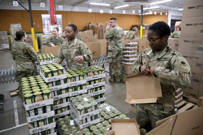 Soldiers pack supply boxes to be distributed at the Freestore Foodbank Mayerson Distribution Center in the Paddock Hills neighborhood of Cincinnati on Monday, March 23, 2020. The Ohio National Guard was deployed to the Distribution center on an ongoing mission to pack and distribute food and supplies to those in need. 
