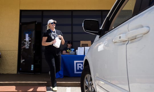 Ashley Alto, a shift supervisor for Rise Cannabis in Bonita Springs delivers product to a customer on Wednesday March 25, 2020. The  company is staying open amid the coronavirus pandemic. They are offering "herb-side pickup" to customers