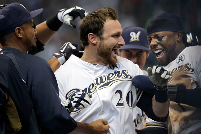 Jonathan Lucroy was swarmed by teammates after hitting the game-winning run during the 10th inning against the Colorado Rockies in the season opener April 1, 2013. The former catcher will be inducted into the Brewers' Wall of Honor on Saturday.