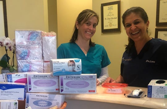 Dr. Ellie Love, right, with dental hygienist Jennifer Camp, is photographed on March 24, 2020, with some of the supplies she has gathered from peers in the medical community.