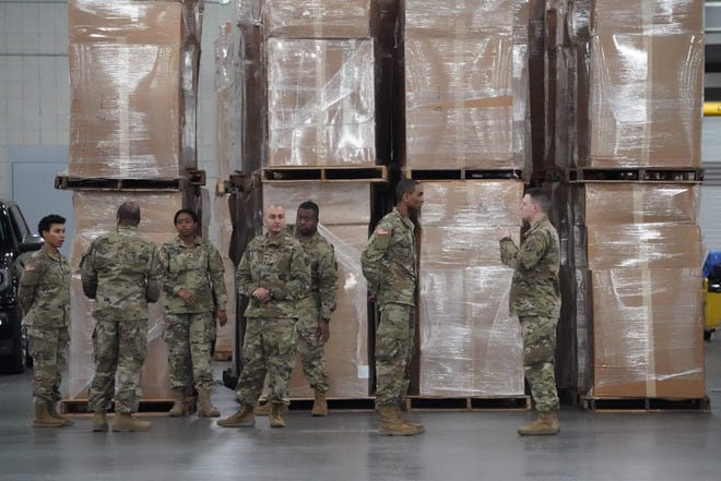 U.S. Army National Guard members walk through the Jacob K. Javits Convention Center in New York City after New York Gov. Andrew Cuomo announced he was converting the center into a field hospital.