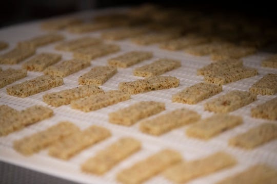 Workers produce jalapeño cheese snack products Thursday, March 26, 2020 ash shown at the Specialty Cheese Co. Inc. in Reeseville, Wis. The Dodge County cheese maker has been swamped with orders for shelf stable cheese snacks such as these Just The Cheese, crunchy toasted cheese snacks.