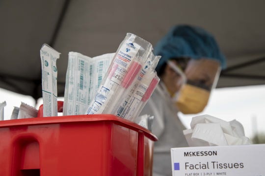 Mary Hermiz, a medical assistant from Redirect Health, prepares to check a patient during a drive-thru coronavirus testing event on March 25, 2020.