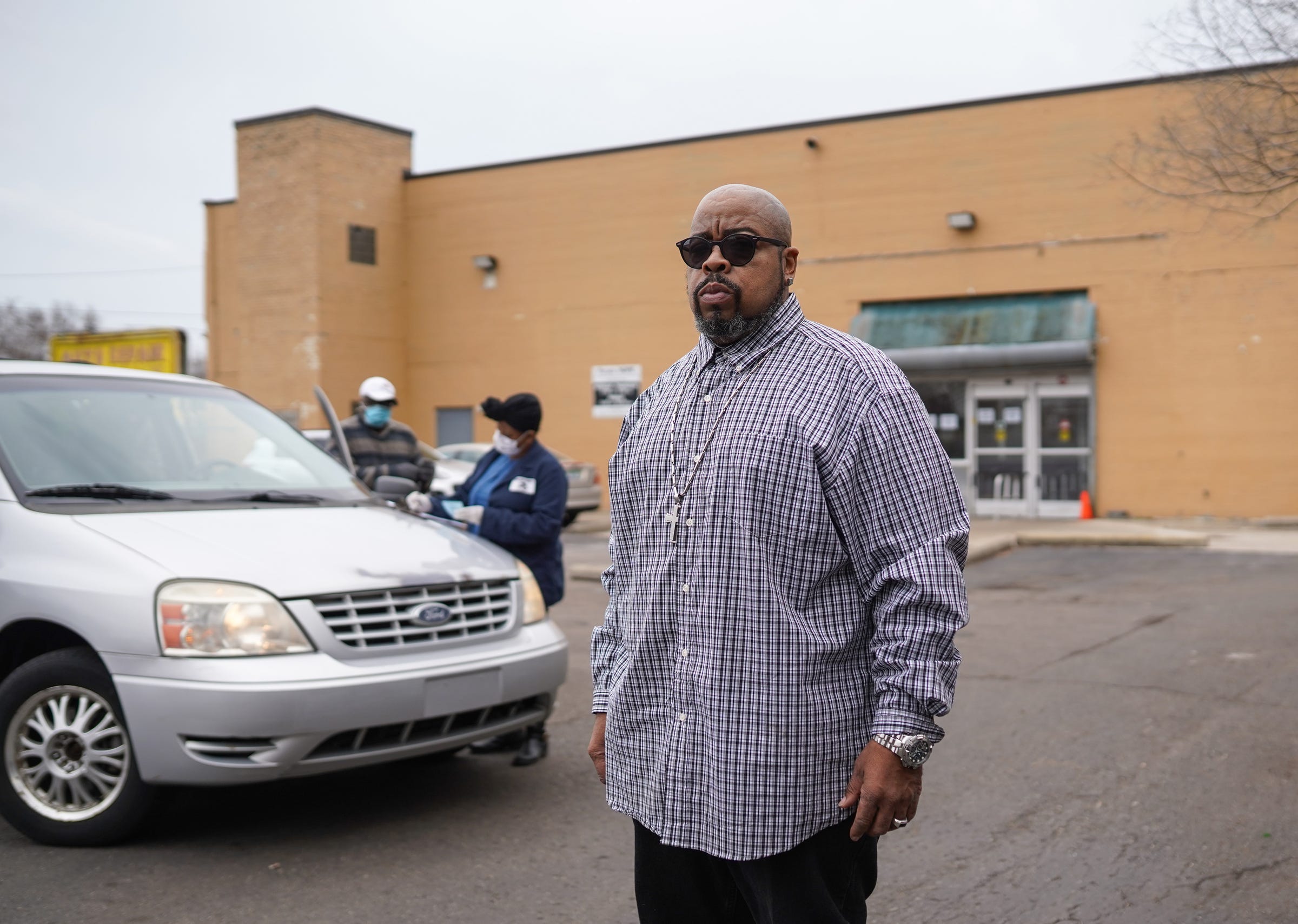 Focus : HOPE Eastside manager Tommie Felton stands outside as community members stop by to pick up food during a food pantry at the organization on Thursday, March 26, 2020 on Detroit's east side.