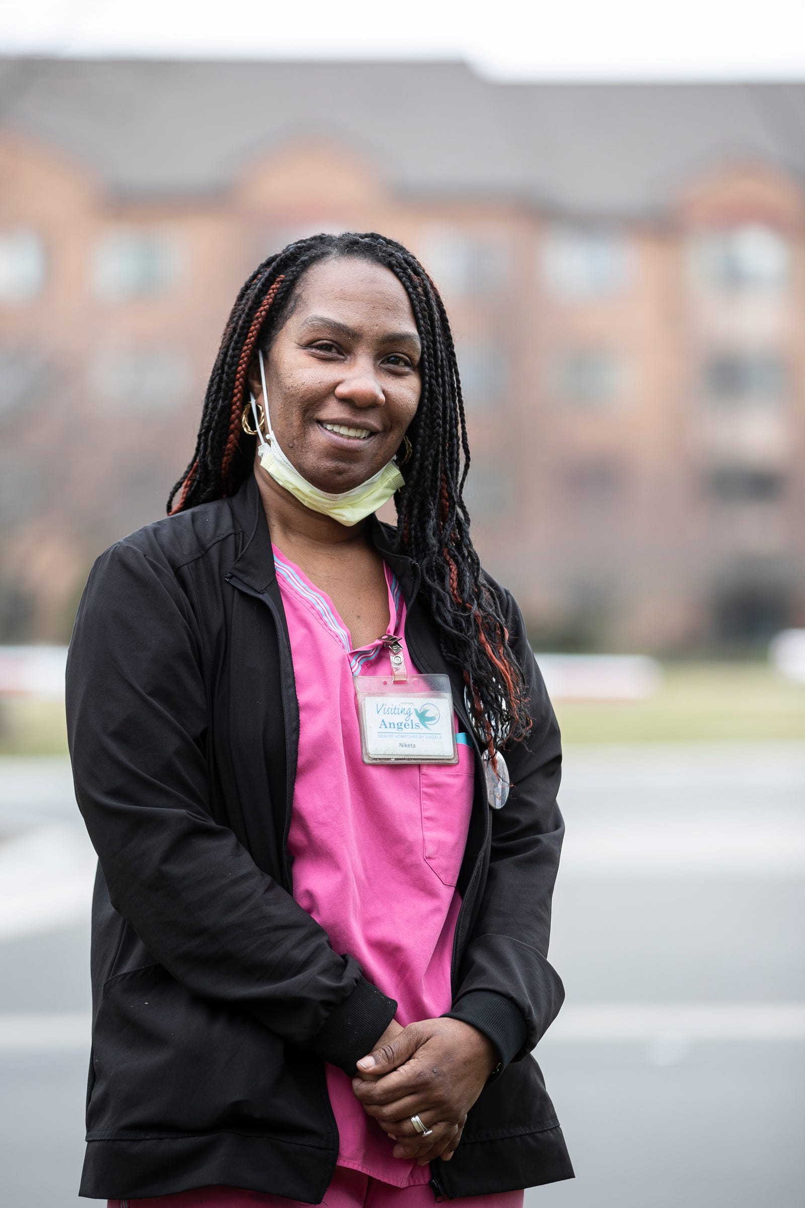 Certified nursing assistant Niketa Taylor poses for a photo after her shift outside of Henry Ford Village, a retirement community in Dearborn, Thursday, March 26, 2020.