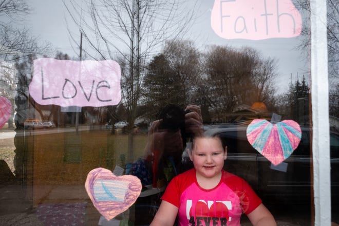 Myla, 6, decorated the window of her family's Capac home with paper hearts and positive words to make people happy during the coronavirus pandemic.