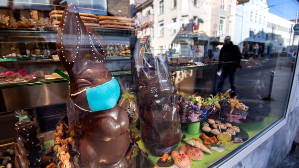 A chocolate Easter bunny with a face mask stands i