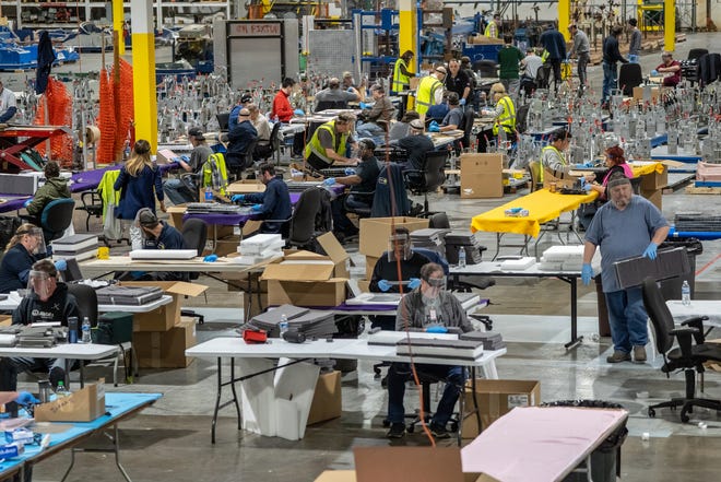 People work on assembling protective face shields at Troy Manufacturing Design a Ford subsidiary in Plymouth on Friday, March 27, 2020. Ford, in cooperation with the UAW, will assemble more than 100,000 critically needed plastic face shields per week to help medical professionals, factory workers and store clerks.