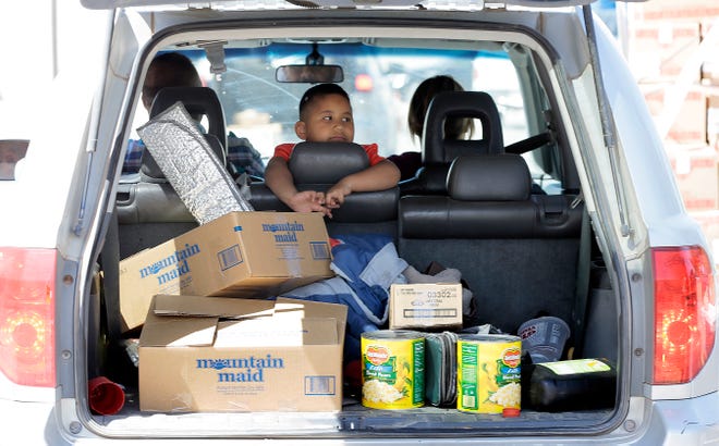 Aaron Martinez watches as volunteers at the El Pasoans Fighting Hunger Food Bank fill his family's SUV with food. Lines for the food bank stretch over a mile at times as El Pasoans' suffer job losses due to the coronavirus.