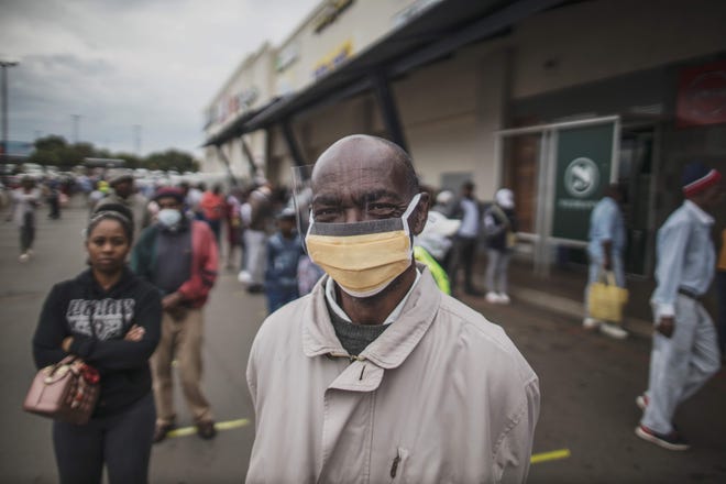 An elderly man from Soweto wears a mask while lining up  at a SASSA (South African Social Security Agency) pay-point in Soweto on March 30, 2020. South Africa came under a nationwide lockdown on March 27, 2020, joining other African countries imposing strict curfews and shutdowns in an attempt to halt the spread of the COVID-19 coronavirus across the continent.