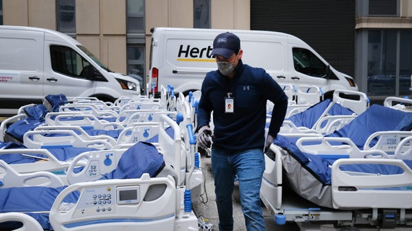 Workers prepare dozens of extra medical beds as th
