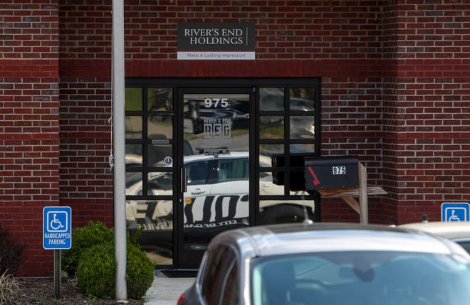 Clarksville Police wait outside in the parking lot after delivering a warning about closing down non-essential businesses to those at River's End Holdings in Clarksville, Tenn., on Wednesday, April 1, 2020. 
