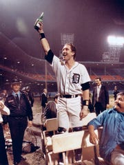Tigers catcher Lance Parrish raises his bottle of champagne to the fans still in the stands long after the Tigers won the 1984 World Series at Tiger Stadium.