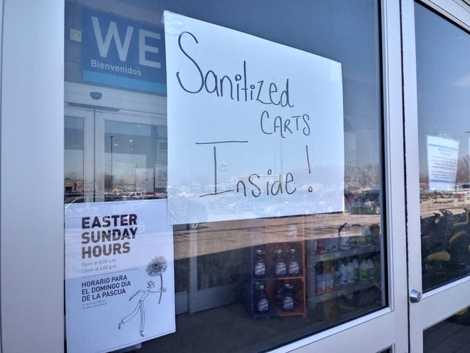 A sign saying there are sanitized shopping carts inside was on the door of Lowes Home Improvement store on Muncie on April 2. Stores across the county have implemented different policies to promote social distancing and halt the spread of COVID-19, but officials have said it may not be enough.