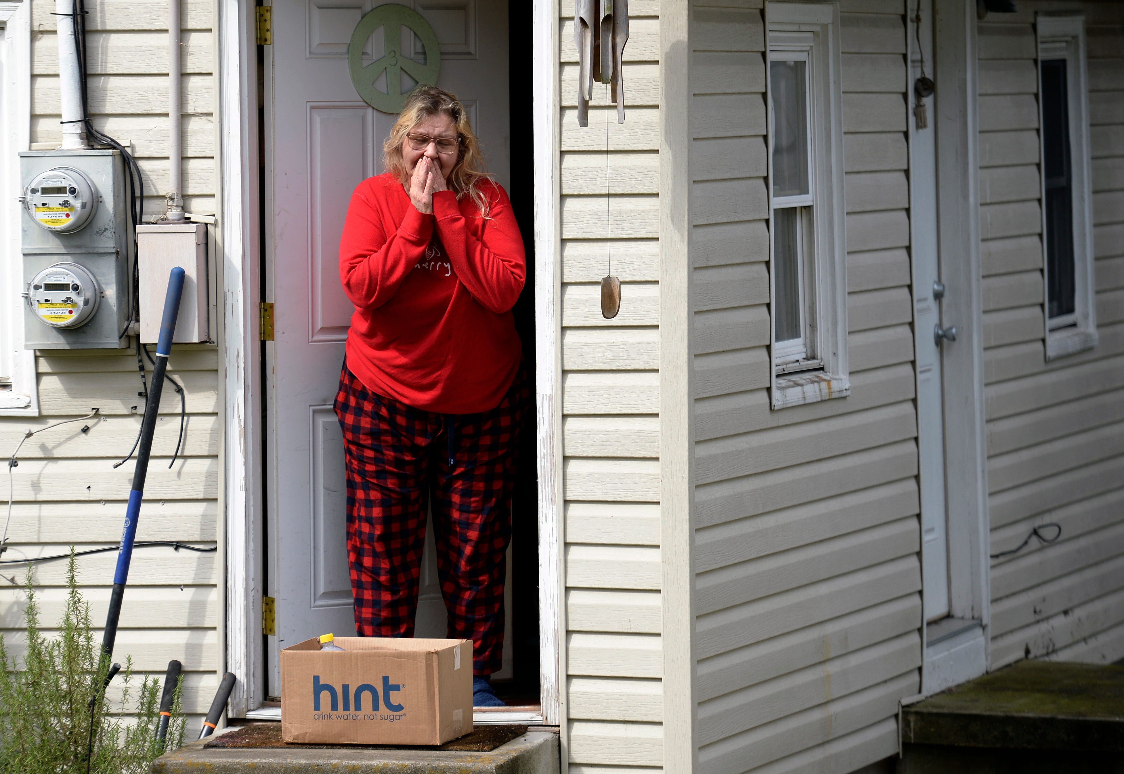Jennifer Clinger reacts after receiving food and other supplies from Thistle Farms volunteer Levi Hummon on March 26 in Nashville, Tenn. Front Porch Delivery started for current and former Thistle Farm clients after the coronavirus started spreading in Nashville.
