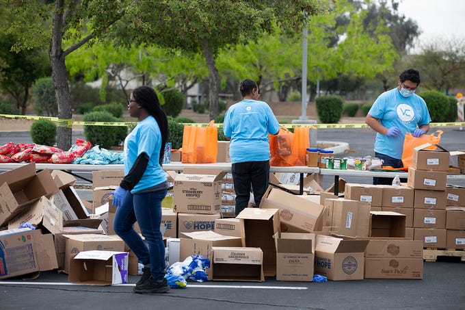 Volunteers at the Vineyard Church of North Phoenix prepare food and cleaning supplies to be handed out to those in need at the church's main campus in Glendale, Ariz. on April 1, 2020. Vineyard Church of North Phoenix and Convoy of Hope partnered together to give out resources to those in need during the COVID-19 pandemic.