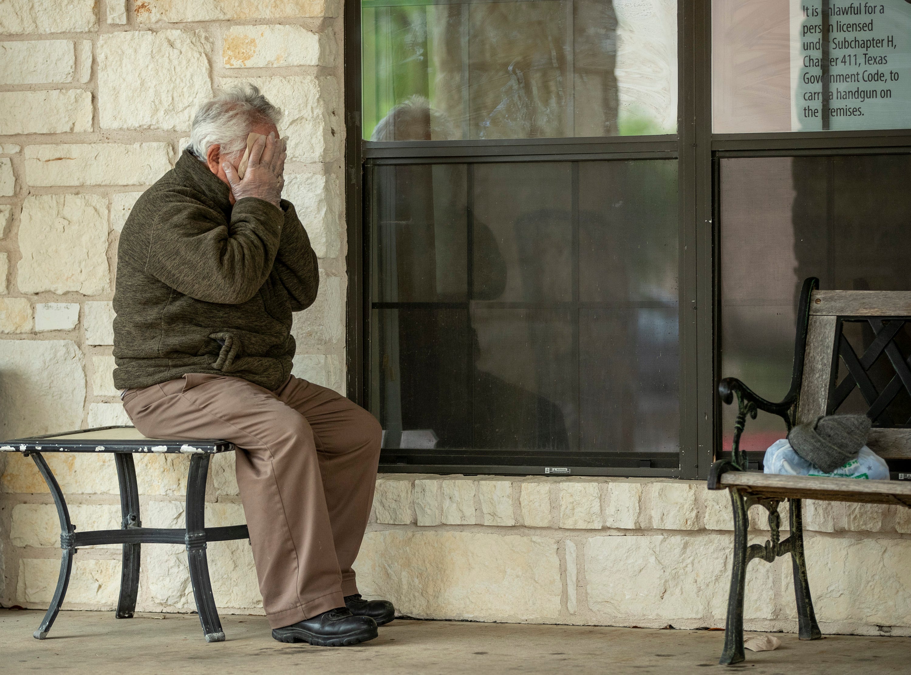 Gusto Monterrosa cries after talking through a window with his daughter who lives at Park Bend Health Center in North Austin on March 22, 2020 on amid the coronavirus pandemic.