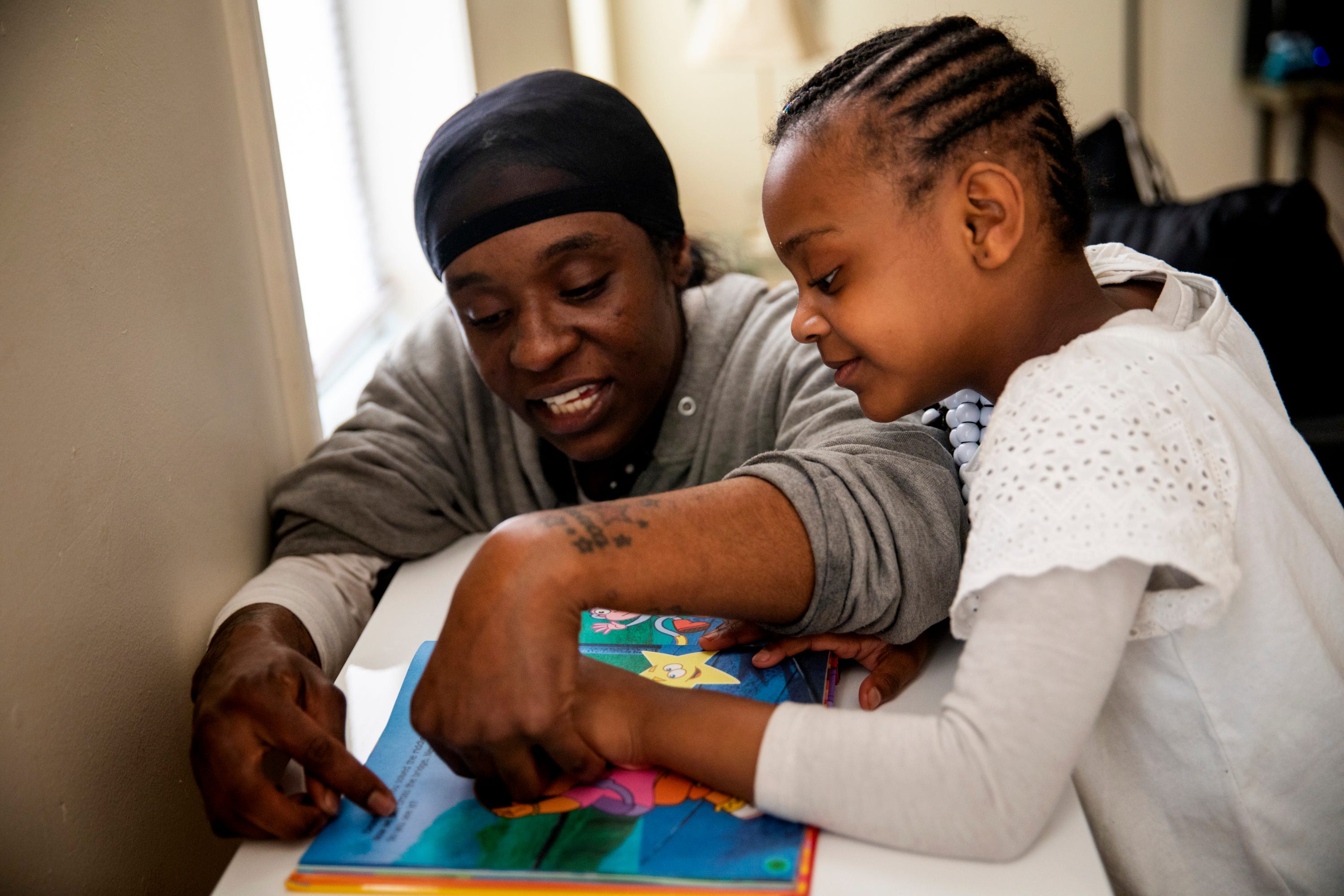 Renee Oliver reads with her daughter Keylah Wagoner, 5, in their apartment in Lower Price Hill on Thursday, April 2, 2020. 