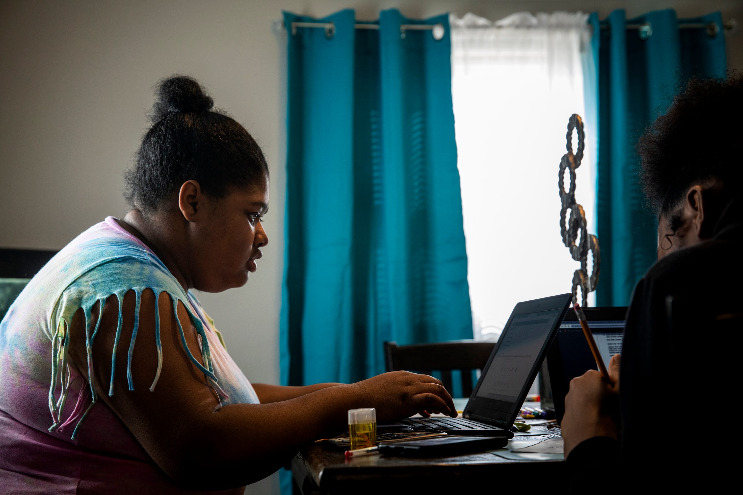 Curiah Simpson, 18, works on her school work at the dining room table in her home in North College Hill on Thursday, April 2, 2020. She is a senior at Diamond Oaks. Simpson said, "I'm sad that I'm not able to graduate and walk. I've waited my whole life to graduate high school."
