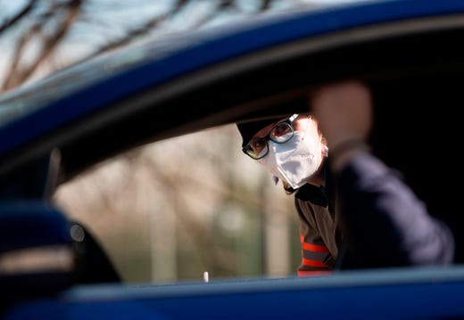 An Arlington County employee speaks with a woman  at a drive-thru donation point created to collect unused and unopened personal protective equipment, cleaning supplies and some food items to help people responding to the coronavirus, COVID-19, pandemic, in Arlington, Virginia on April 3, 2020.