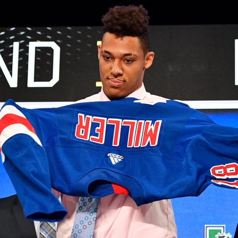 K'Andre Miller puts on a team jersey after being s