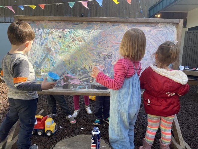 Children paint outside as part of their day at Small Wonders, a child care center in Portland, Oregon. The center has closed both of its schools in reaction to the global coronavirus outbreak.
