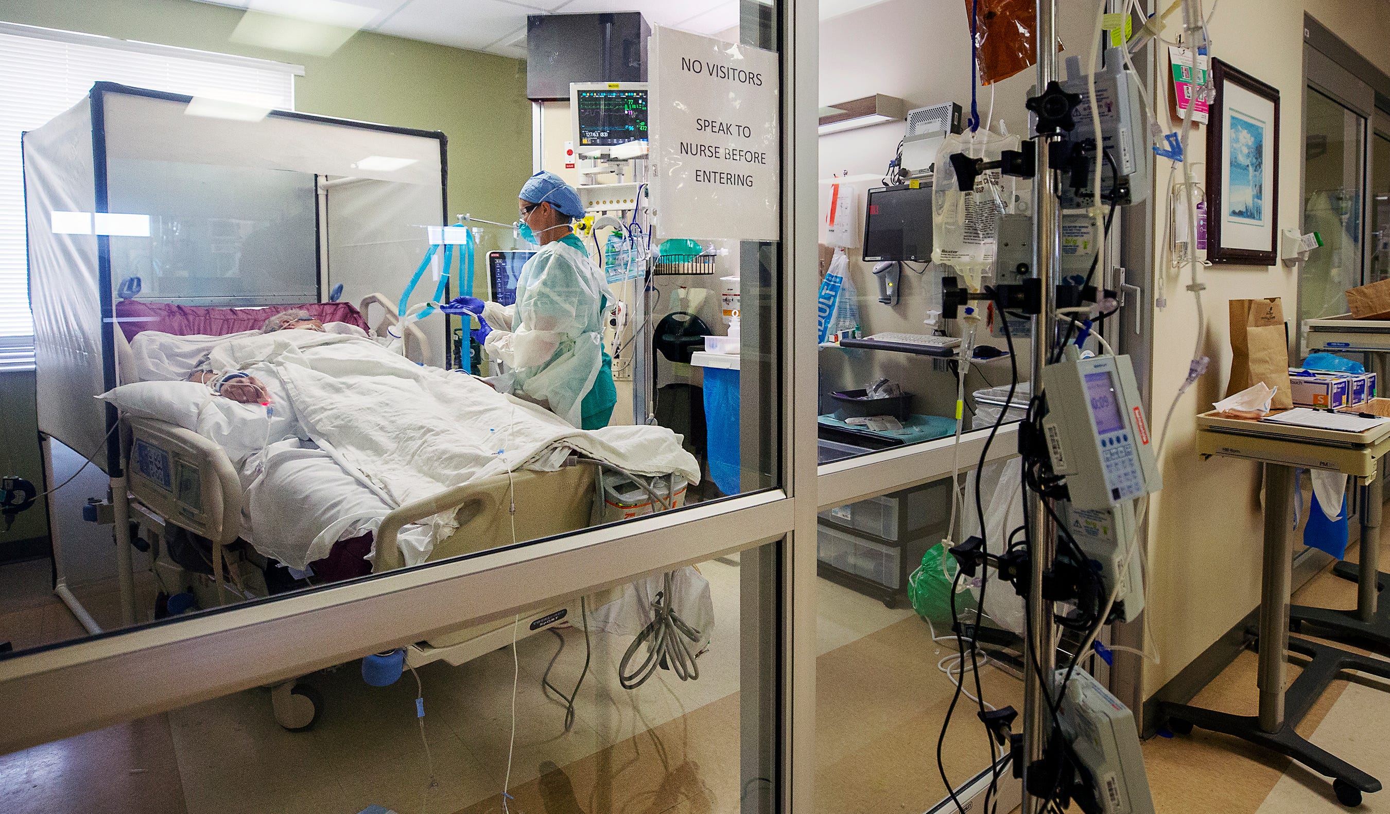 Registered Nurse Aubry Sander cares for a COVID-19 patient in a negative pressure room (NPR) at Gulf Coast Medical Center in Fort Myers, Fla. NPRs help prevent cross-contamination from room to room. The room's ventilation system generates pressure lower than the surroundings, allowing air to flow in but not out.