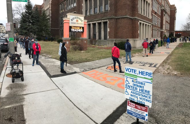Voters circle around the block on Locust Street and keep a safe distance from each other at Riverside University High School in Milwaukee during election day April 7, 2020.