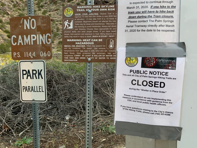 A sign advises people that Palm Springs' North Lykken trail is closed to the public Tuesday, April 7, 2020. City staff says the signs were accidentally posted and trails are still open to the public, but parking is no longer allowed at trailheads to help prevent the spread of coronavirus.