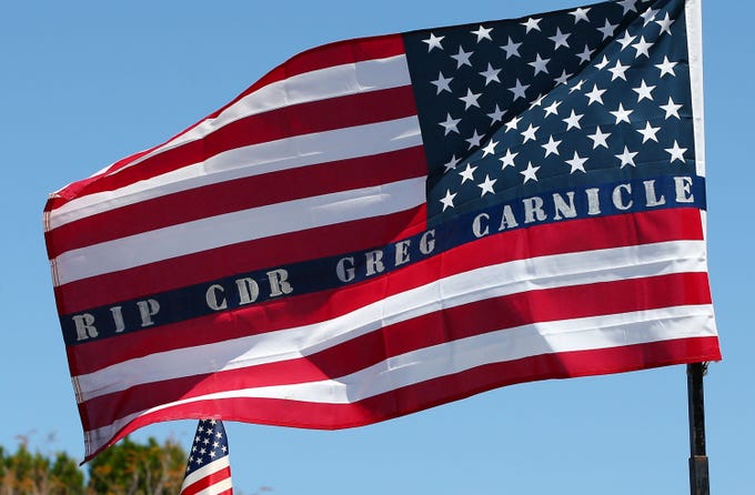 Apr. 7, 2020; Phoenix, AZ, USA; A U.S. flag carries a message for Phoenix Police Commander Greg Carnicle during his funeral mass at Saint Jerome Catholic Church in Phoenix. Commander Greg Carnicle was a 31-year veteran who was shot and killed on duty. Mandatory Credit: Rob Schumacher/The Arizona Republic via USA TODAY NETWORK