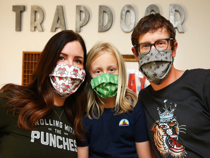 Apr. 6, 2020; Scottsdale, AZ, USA; Local artists Jenn and Jon Arvizu with their son Charley (middle) wear their homemade masks during the COVID-19 health crisis at their home studio in Scottsdale. After making masks for family and friends, they are now taking orders.