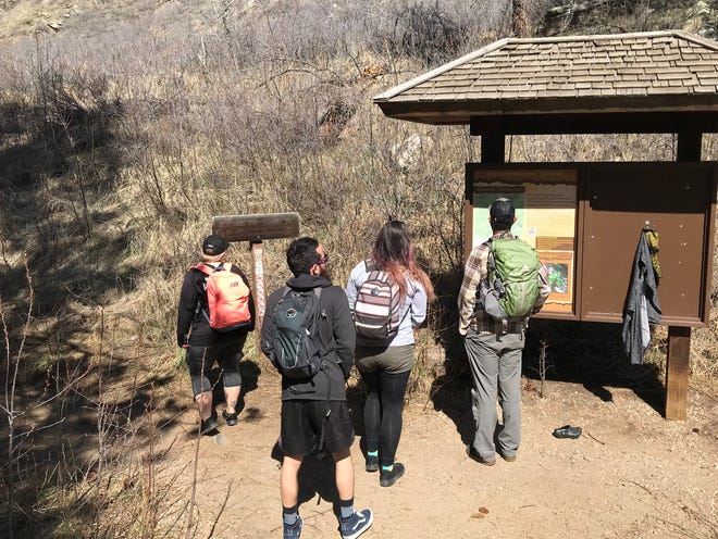 In this April 2020 file photo, hikers look at the Greyrock Trail map. Recently, emergency responders were able to help a hiker who got stuck near the top of Greyrock Mountain using livestreamed video from a climber.