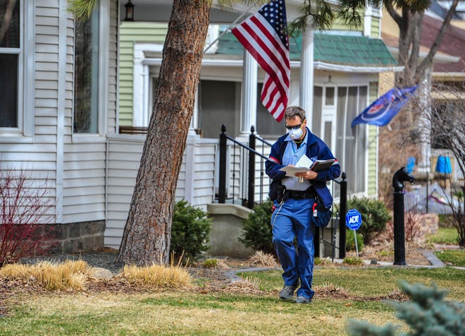 A U.S. Postal Service mail carrier delivers mail near downtown Great falls Tuesday. Paper census questionnaires were mailed to about 64 million households across the nation Wednesday. Residents can also respond at 2020census.gov.
