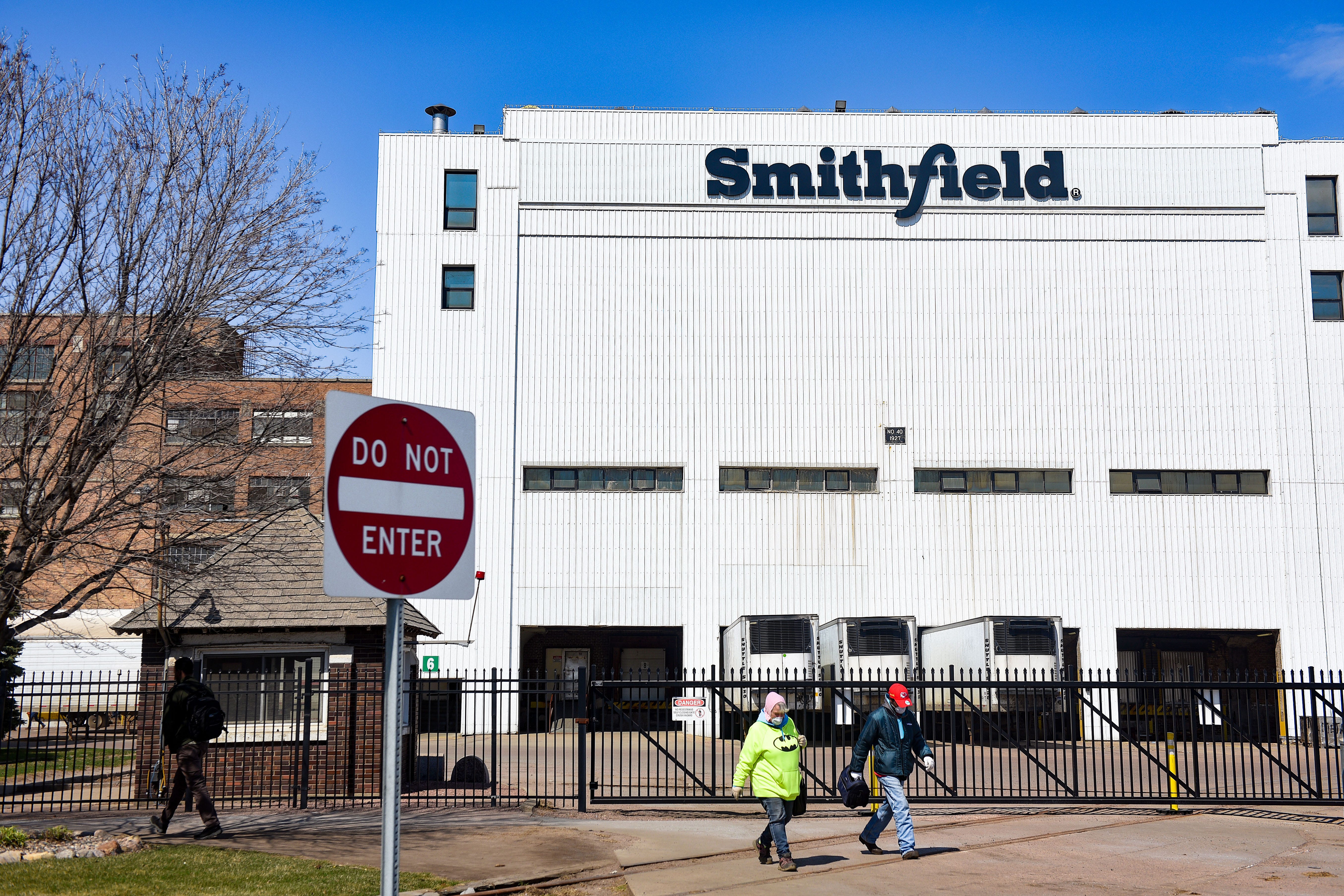 Smithfield Foods, Inc. employees wear masks as they leave at the end of their shift on Wednesday, April 8, at the food processing plant in Sioux Falls.